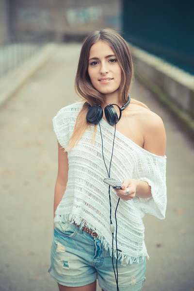 Young beautiful Ukrainian lady listening to music and looking forward in autumn